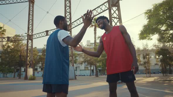 Cinematic footage of a street basketball game outdoor.