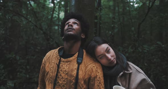 Woman leans on man while in forest