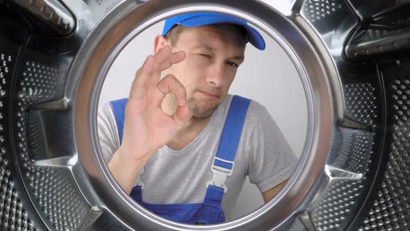 Washing machine repair worker looks inside mababan and shows class.