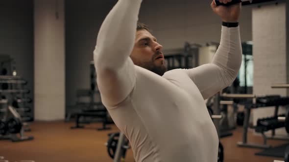 Male Doing Exercises for the Chest and Biceps on the Pull of the Upper Block
