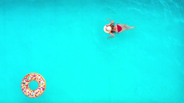 View From the Top As a Woman in Red Swimsuit Swims in the Pool