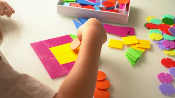 a Girl at a Round White Table Plays Educational Games a House Made of Designer Children's Hands