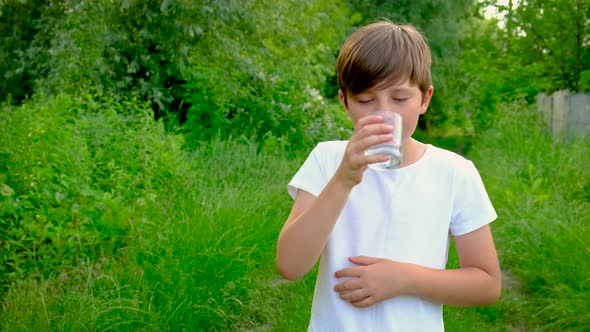 The Child Drinks Water From a Glass