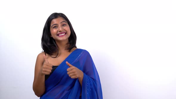 Attractive and beautiful Indian young girl pointing to the right for product placement