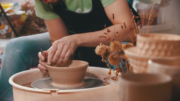 Pottery - a Man with an Iron Spatula Is Helping Himself Maintaining the Shape of a Bowl
