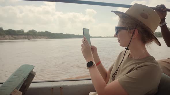 Woman On Africa River Safari Adventure. Safari Trip On Tanzania Selous. Tourist In Hat On Safari.