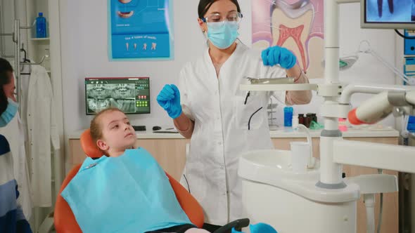 Dentist Checking with Mirror Dental Health of Little Girl Patient