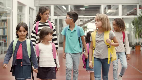 Friendly Children with Colorful Walking in School Hallway