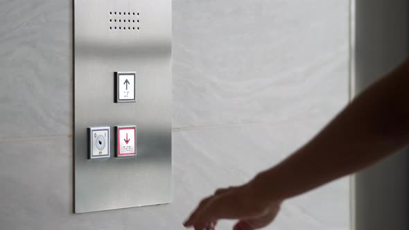 Female Hand Pushing Elevator Button in Office Center or Hotel. Young Woman Pressing Lift Button Up