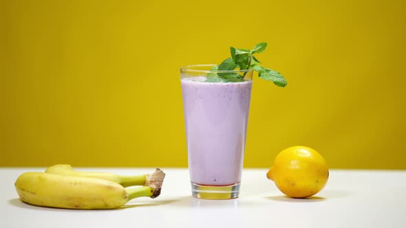 Lemon Rolling on Table to Glass with Organic Vitamin Smoothie