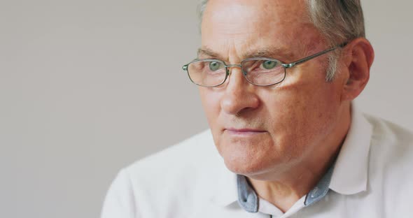 Closeup Portrait of a Serious Grayhaired Senior Man in Glasses