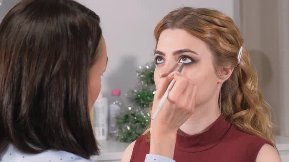 Applying Makeup. Giving the Eyes of the Young Girl's Expression. Stroke the Eye Contour with a