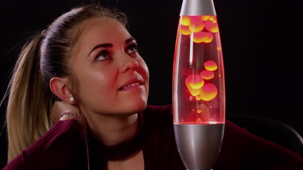 Pretty Woman Looking At A Lava Lamp