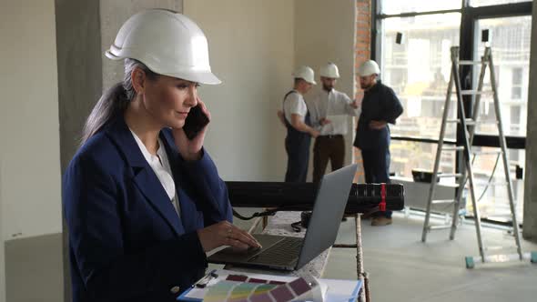 Architect Talking Cellphone During Work on Laptop