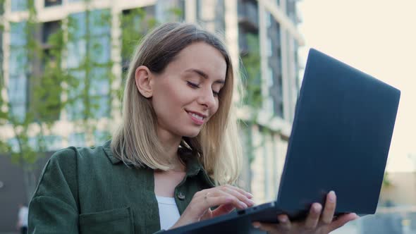 Cheerful Beautiful Young Business Woman Working Online Typing Message on Laptop