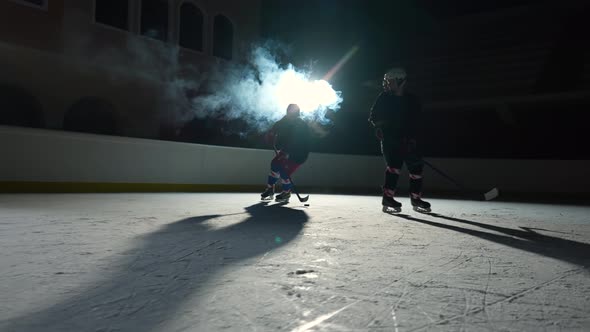 Two Men Hockey Player in Uniforms Masterfully Dribbles Hitting Puck with Stick and Forward Scores