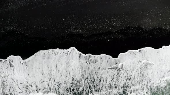 White Foamy Waves Coming Into Black Sand Of Reynisfjara Beach In Iceland. - aerial ascend