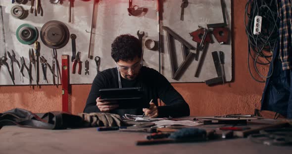 A Blacksmith Uses a Tablet to Create a Sketch of a Future Product