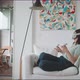 Young woman sitting in armchair using VR goggles and handles - VideoHive Item for Sale