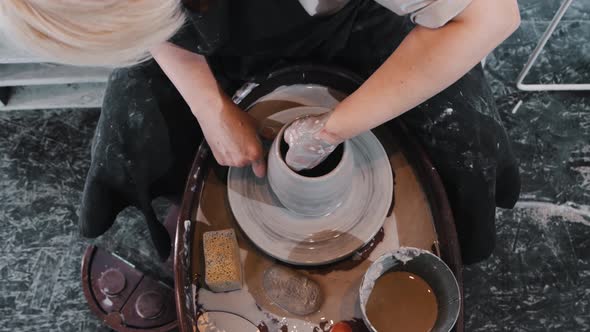 Pottery  an Elderly Woman Thinning the Sides on Wet Clay Pot on the Wheel