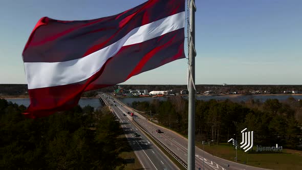 HUGE National Latvian Flag Fluttering on Wind with Jurmala City in Background Aerial View