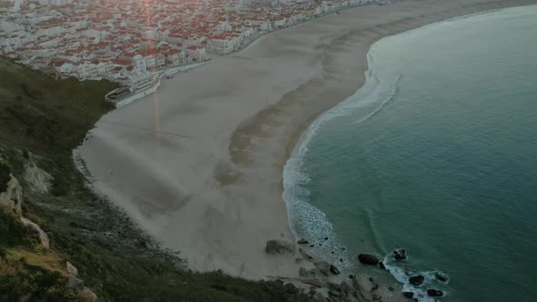 Sunbeam Over Townscape On The Sandy Seashore Of Praia do Norte (North Beach), Nazare Portugal. - Aer