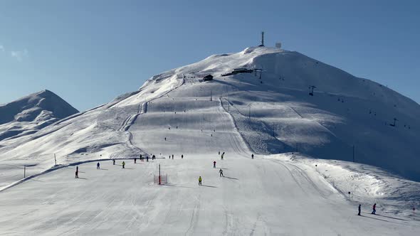 People skiing on snowy slope at ski resort in the mountains