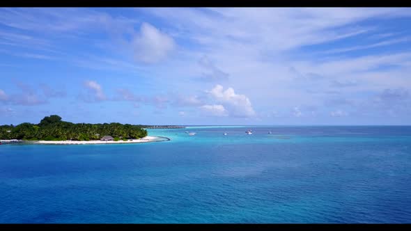 Aerial scenery of tranquil tourist beach voyage by aqua blue sea and white sandy background of a day