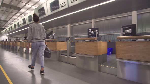 The Girl Goes To the Terminal for Registration with a Bag and Passport