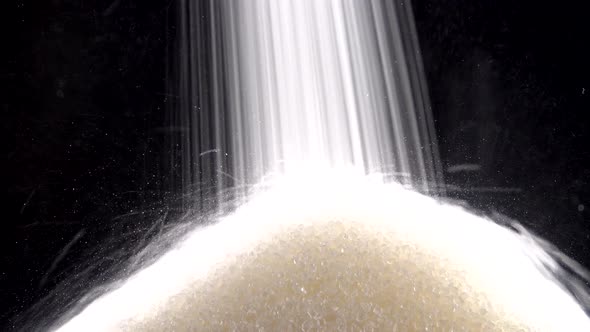 Sugar is pouring on a black background.