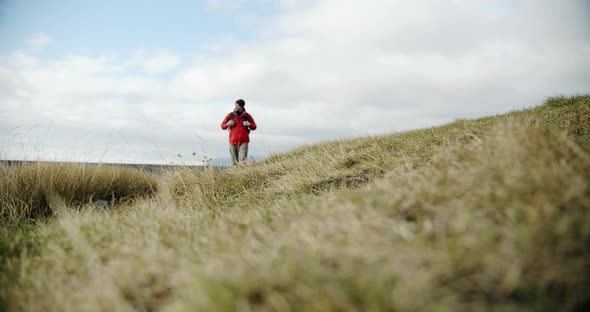 View of a Man Legs in Boots Walking on Green Moss and Grass in Iceland.