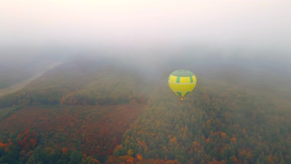 Balloon Flying Over the Autumn Forest in Thick Fog and Cloudy Weather, View From Above