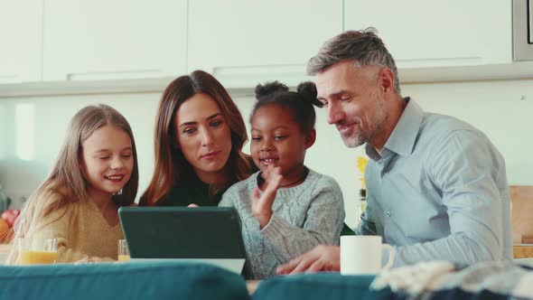 Cheerful multinational family talking by video call