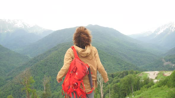 Traveler Man with Backpack Raised Hands. Mountains Landscape on Background