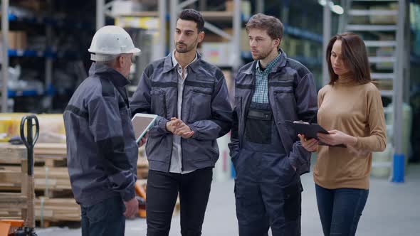 Group of Employees Listening Instructions of Foreman in Warehouse and Start Working