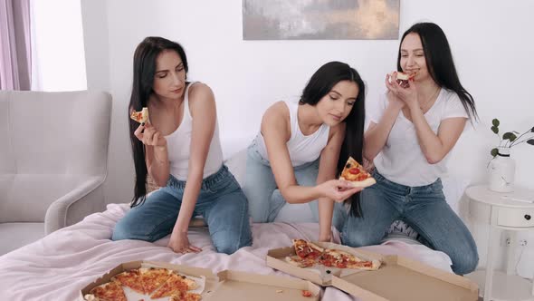Three Girlsfriends Are Eating Pizza in Bed and Having Fun
