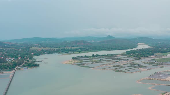 Aerial view of Ong Cop Bamboo Bridge, shrimp ponds next to Vietnam's national highway