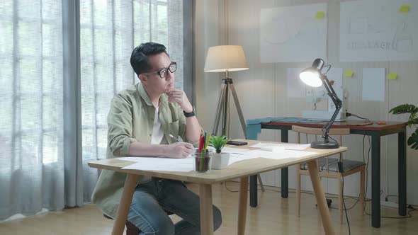 Asian Man Designer Thinking While Drawing On The Layout Bond At The Office