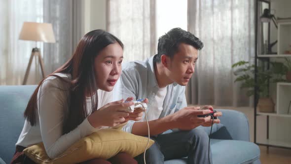 Young Asian Couple Is Playing Video Games At Home