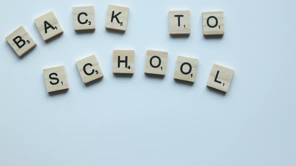 Words Back to School Wooden Letters on White Background and Colorful Pencils Spread in the Bottom
