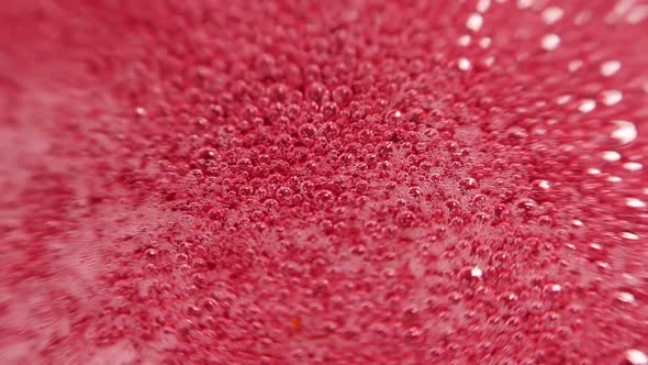 Raspberry syrup. Pink background with bubbling bubbles and raspberries.