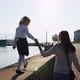 A girl in school uniform is walking on the railing of the promenade with mother. - VideoHive Item for Sale
