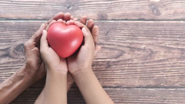 Senior Women and Child Holding Red Heart Close Up