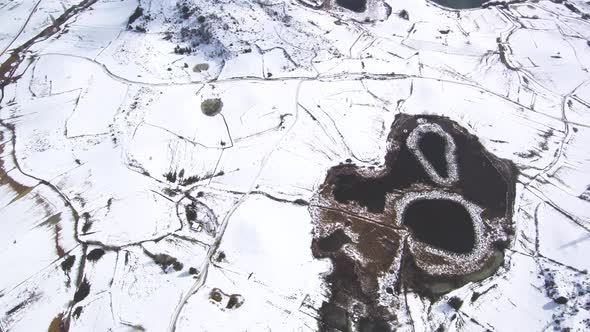 This is a footage of mountains in a snow day, you can also see big lakes and a village. This is in S