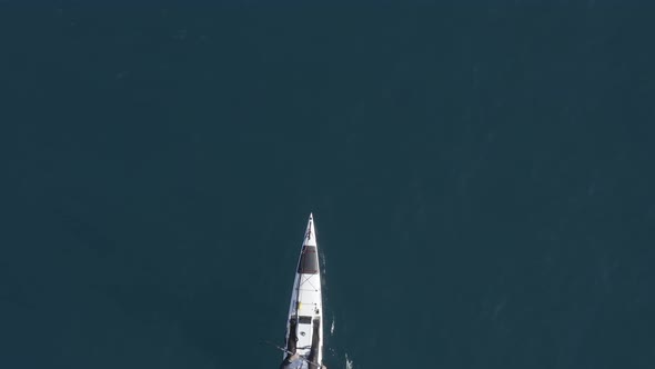 Single seat fishing canoe rowing at calm open sea water, Aerial view.