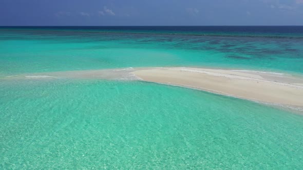 Wide angle overhead tourism shot of a white sand paradise beach and blue water background 