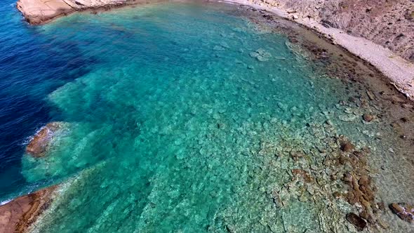 Clear and Shallow Sea Water of the Cove Surrounded by Stone and Rocky Coastline