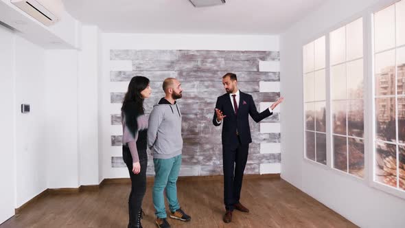 Successful Real Estate Agent Talking with Young Couple