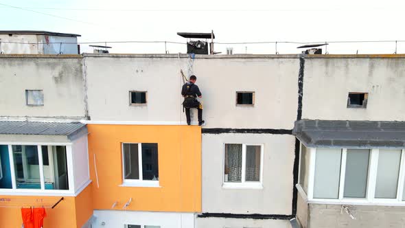 Worker Go Down To a Construction Site of a High-rise Building. Dangerous Work in High-altitude