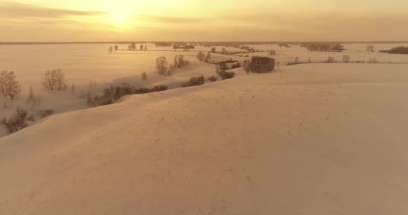 Aerial View of Cold Arctic Field Landscape Trees with Frost Snow Ice River and Sun Rays Over Horizon